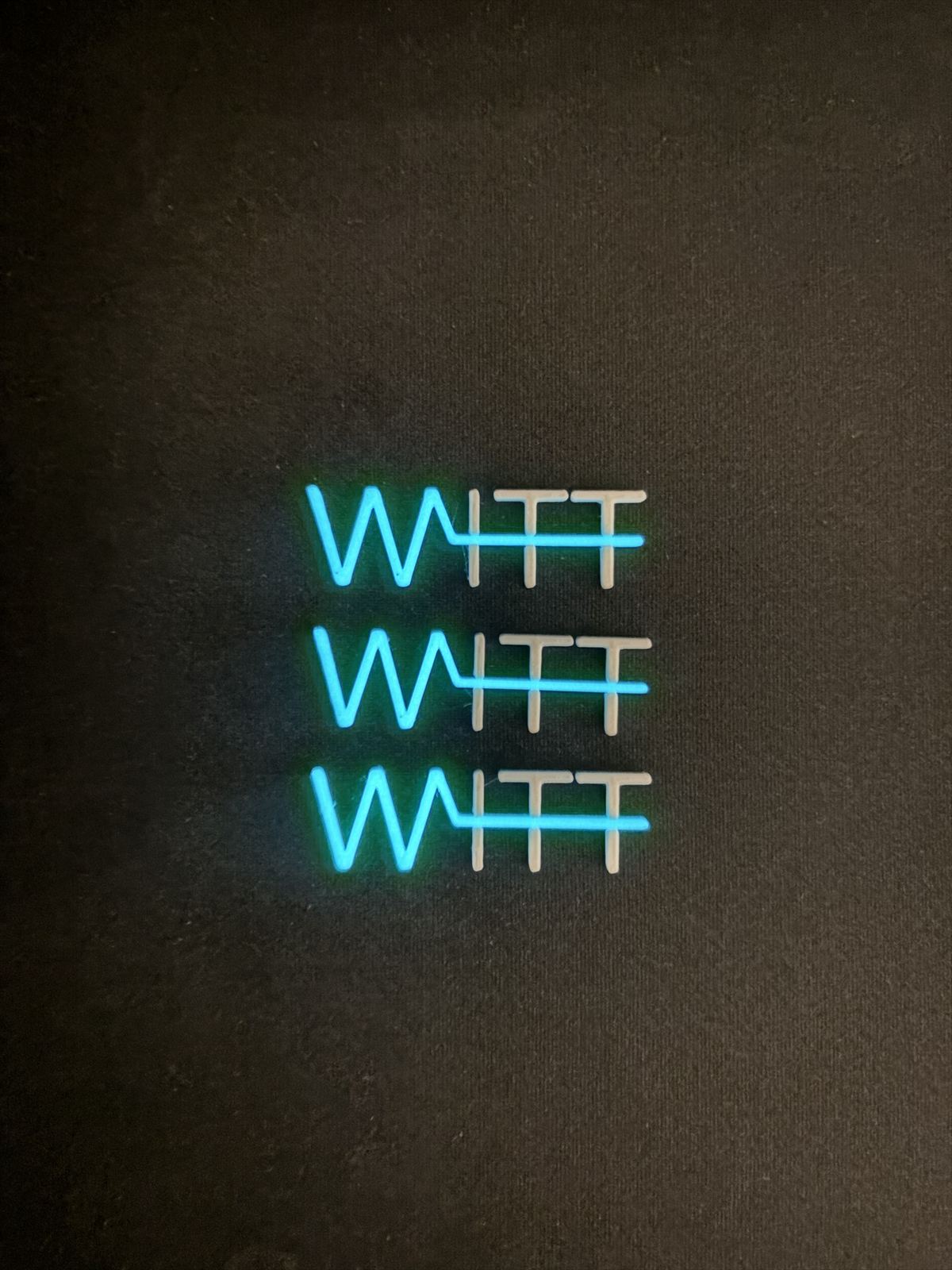 Three glow-in-the-dark WITT logos printed in two colours